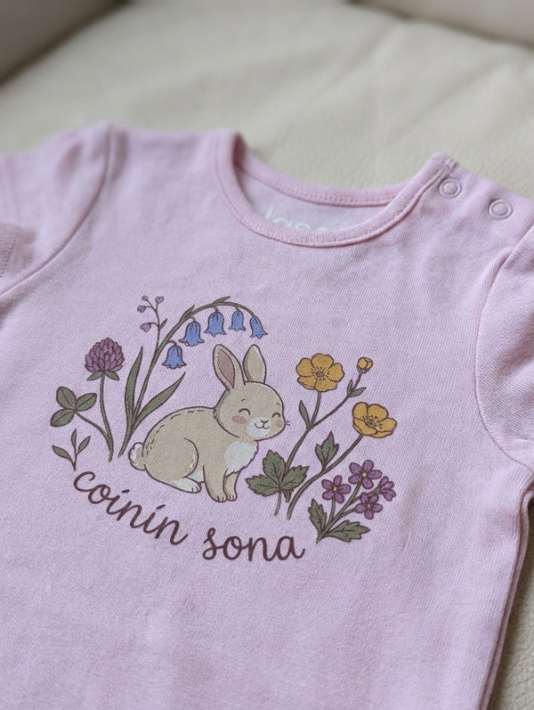 Close-up detail of rabbit-floral illustration on pink bodysuit