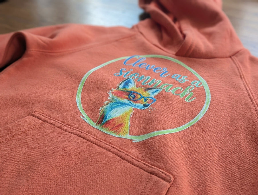 Close-up detail of fox illustration on orange hoodie