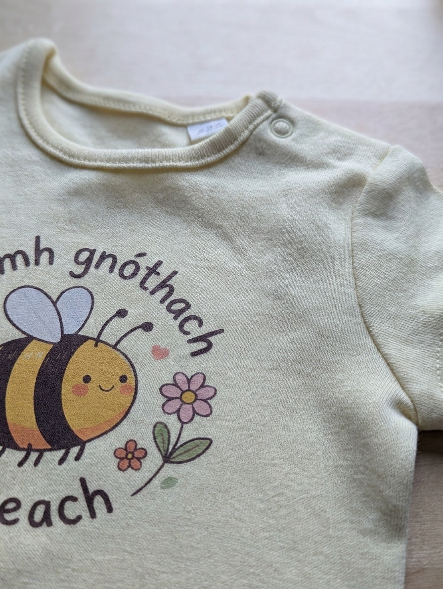 Close-up detail of bee illustration on butteryellow bodysuit