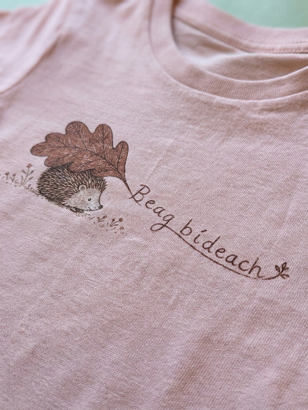 Close-up detail of beagbideach illustration on peach t-shirt